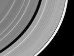 Imagen del anillo F de Saturno interrumpido por el impacto de un meteorito con la luna Pandora al fondo.