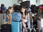 Algunos viajeros esperan la salida de sus vuelos en la Terminal 1 del Aeropuerto de El Prat, en Barcelona.