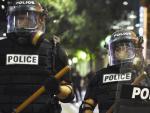 Polic&iacute;as antidisturbios permanecen en guardia durante la noche de enfrentamientos en la ciudad de Charlotte.
