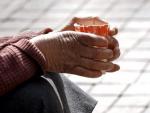 Detalle de las manos de una persona pidiendo limosna en la calle.