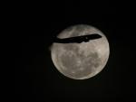 Un avi&oacute;n pasa por delante de la luna llena, en R&iacute;o de Janeiro (Brasil).