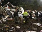 Varios miembros de los servicios de emergencia y agentes de la polic&iacute;a colombiana trabajan entre los restos del avi&oacute;n siniestrado.