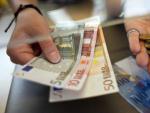 Fotograf&iacute;a de archivo tomada el 8 de junio de 2011 que muestra a una mujer cambiando francos suizos por euros en un mostrador en Kreuzlingen (Suiza).