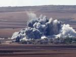 Columnas de humo gris se elevan sobre la poblaci&oacute;n de Minaze tras un aparente bombardeo de las fuerzas de la coalici&oacute;n lideradas por EE UU contra el grupo radical Estado Isl&aacute;mico (EI), cerca de la localidad kurdo siria Kobani.