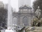 La Cibeles, con la Puerta de Alcal&aacute; de fondo, nevando en Madrid.