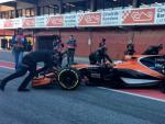 Mec&aacute;nicos de McLaren empujan el coche de Stoffel Vandoorne al box del equipo en el circuito de Montmel&oacute;.