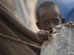 Un ni&ntilde;o observa la c&aacute;mara desde la tienda de su familia en un campamento para desplazados internos a las afueras de Qardho (Somalia). La crisis alimentaria causada por la falta de lluvias en la regi&oacute;n afecta a 5,6 millones de personas, seg&uacute;n la Cruz Roja.