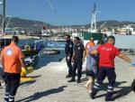 Varios m&eacute;dicos ayudan a inmigrantes indocumentados a desembarcar en el puerto de la isla de Lesbos, Grecia.