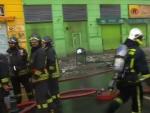 Imagen que muestra a los bomberos trabajando cerca de un edificio da&ntilde;ado por el terremoto que ha sacudido el centro de Chile.