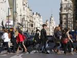 Un grupo de personas cruza por un paso de peatones en la c&eacute;ntrica Gran V&iacute;a de Madrid.