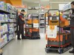 Dos trabajadores realizan un pedido online en un supermercado de Alicante.