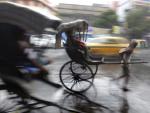 Un hombre corre con su &quot;rickshaw&quot; bajo la lluvia en Calcuta (India). La temporada de lluvias del monz&oacute;n se da de junio a octubre.
