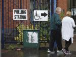 Dos personas acuden a votar a un colegio electoral en Belfast (Reino Unido).