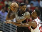 LeBron James, de Miami Heat, protege el bal&oacute;n ante Jimmy Butler, de Chicago Bulls.