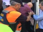 Silv&aacute;n ayuda a descender de una ambulancia a un anciano evacuado
