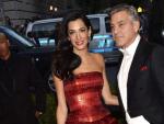 George Clooney (d) y su esposa Amal Alamuddin Clooney, en la alfombra roja de la gala. George y Amal Clooney derrocharon elegancia, ella con un palabra de honor rojo desembocado en volantes de Maison Margiela.