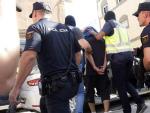 Efectivos de la Polic&iacute;a Nacional traslada a un detenido en el marco de una operaci&oacute;n antiterrorista en Melilla.