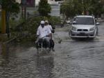 Varias personas transitan en sus veh&iacute;culos por una calle inundada horas antes del paso del hurac&aacute;n Mar&iacute;a, en Punta Cana (Rep&uacute;blica Dominicana).