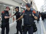 Un agente de la Polic&iacute;a Nacional se despide de un Mosso de Escuadra a las afueras de dos hoteles de Pineda de Mar (Barcelona).