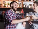 Dos amigos tomando cerveza en una barra de bar.