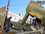 Dos hombres inspeccionan los restos de un edificio da&ntilde;ado tras el terremoto de 7,3 grados en la escala Richter registrado en la frontera entre Ir&aacute;n e Irak.