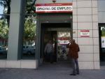 Un hombre sale y otro entra a una oficina de empleo de Madrid.
