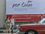 Un veh&iacute;culo cruza frente a un cartel alusivo a las elecciones de delegados municipales en La Habana (Cuba).