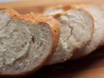 Varias rebanadas de pan de una baguete, elaborada con harinas refinadas.