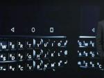Un asistente al Mobile World Congres de 2018 en Barcelona, junto a una pantalla que muestra el teclado de uno de los &uacute;ltimos modelos de BlackBerry, la BlackBerry KEYone.