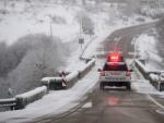Un coche de la Guardia Civil circula por una carretera, con un aviso luminoso de 'nieve', en el municipio de Montederramo (Ourense).