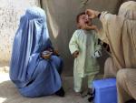 Dos enfermeras administran a un ni&ntilde;o la vacuna contra la polio en Kandahar (Afganist&aacute;n).