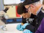 Un abuelo y su nieto realizan un experimento en el Laboratorio de la UPNA.
