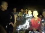 Un miembro de las fuerzas especiales de la Marina tailandesa, con los ni&ntilde;os atrapados en la cueva Tham Luang, en Tailandia, en una captura de v&iacute;deo.
