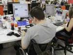 Una personas con discapacidad frente a un ordenador.