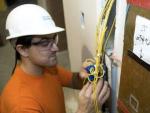 Un electricista revisando los cables de una instalaci&oacute;n.