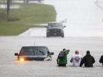 Varios vecinos ayudan a un conductor atrapado por las inundaciones provocadas por el hurac&aacute;n Florence en la ruta 17 cerca de Holly Rodge, en Carolina del Norte.