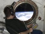El astronauta Greg Chamitoff se asoma por una ventana del m&oacute;dulo japon&eacute;s Kibo de la Estaci&oacute;n Espacial Internacional, durante la misi&oacute;n espacial de noviembre de 2008.