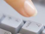 Una mujer presionando un teclado de un ordenador.