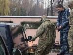 Miembros de los Servicios de Seguridad de Rusia escoltan a un marinero ucraniano detenido, en el tribunal de Simfer&oacute;pol, en Crimea.