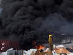 Un bombero solicita ayuda tras quedarse sin agua entre los escombros que dej&oacute; una fuerte explosi&oacute;n en una fabrica de pl&aacute;sticos en Santo Domingo, Rep&uacute;blica Dominicana.