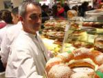 Un pastelero muestra un rosc&oacute;n de Reyes reci&eacute;n hecho.