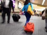 Pasajeros con sus maletas en los pasillos de un aeropuerto.
