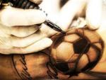 Un tatuador perfecciona un bal&oacute;n de f&uacute;tbol.
