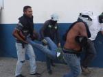 Simpatizantes de Juan Guaid&oacute; ayudan a un herido durante una manifestaci&oacute;n.