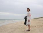 Una mujer vestida de enfermera de la &eacute;poca visita la hist&oacute;rica playa de Utah, en la costa de Normand&iacute;a (Francia)