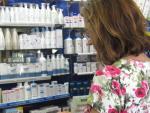 Una mujer elige medicamentos en una farmacia.