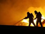 Unos bomberos trabajan para extinguir un incendio.
