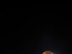 La Luna eclipsada asoma por la monta&ntilde;a de Las Tricias, en el municipio de Garaf&iacute;a, al norte de la isla de La Palma.