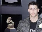 Nick Jonas posa en la alfombra roja de la 60 edici&oacute;n de los Premios Grammy luciendo una rosa blanca en apoyo del movimiento #MeToo contra el acoso sexual.