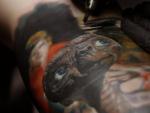 Un artista realiza un tatuaje de E.T., en el brazo de un cliente, durante la d&eacute;cima edici&oacute;n de 'Expotatuaje', en Medell&iacute;n (Colombia).